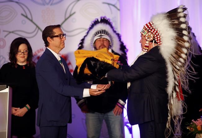 Southern Chiefs' Organization Grand Chief Jerry Daniels (right) gifts hides to Hudson’s Bay Company governor Richard Baker at a Hudson’s Bay Co. transfer ceremony in Winnipeg Friday, April 22, 2022. One of the landmark stores formerly run by the Hudson’s Bay Co. is about to undergo a major transformation in the name of reconciliation with Indigenous people. THE CANADIAN PRESS/John Woods