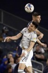 Sporting Kansas City defender Robert Voloder, back, and Columbus Crew forward Miguel Berry (27) vie for the ball during the second half of an MLS soccer match Saturday, April 23, 2022, in Kansas City, Kan. (AP Photo/Charlie Riedel)