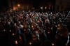 Orthodox worshipers hold candles during the Easter religious service at the Brancusi Parish Church in Bucharest, Romania, Sunday, April 24, 2022. The religious service was also attended by dozens of Ukrainian refugees living in a social center belonging to the church. (AP Photo/Andreea Alexandru)