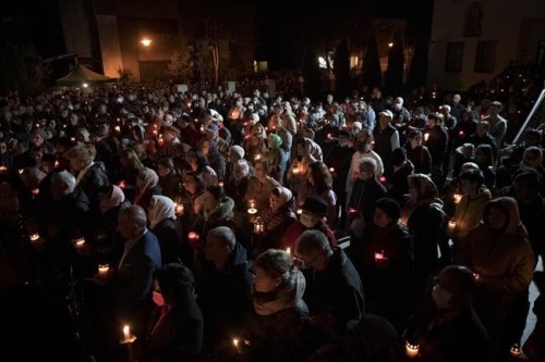 Orthodox worshipers hold candles during the Easter religious service at the Brancusi Parish Church in Bucharest, Romania, Sunday, April 24, 2022. The religious service was also attended by dozens of Ukrainian refugees living in a social center belonging to the church. (AP Photo/Andreea Alexandru)