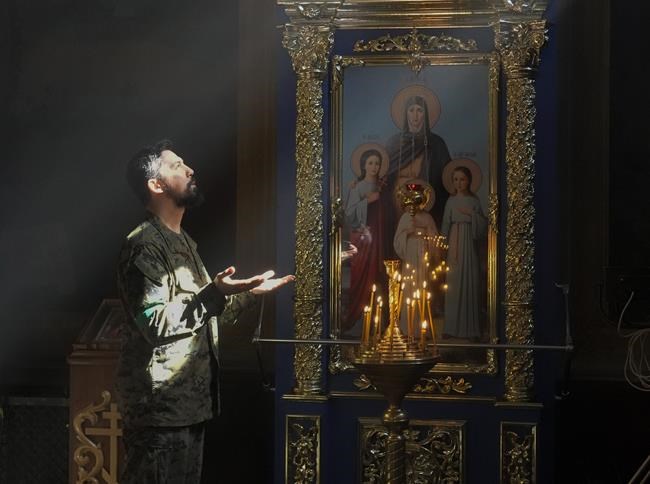 A Ukrainian soldier prays in St. Michael Cathedral during Orthodox Easter celebrations in Kyiv, Ukraine, Sunday, April 24, 2022. (AP Photo/Efrem Lukatsky)