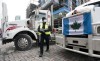 A police officer walks between parked trucks as he distributes a notice to protesters, Wednesday, Feb. 16, 2022 in Ottawa.THE CANADIAN PRESS/Adrian Wyld