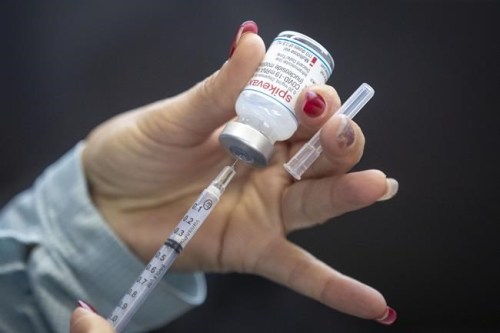 A person draws out Moderna vaccine during a drive through COVID-19 vaccine clinic at St. Lawrence College in Kingston, Ontario, on Sunday January 2, 2022.&nbsp;American vaccine maker Moderna will announce Friday it intends to build its promised Canadian production facility in the Montreal area.&nbsp; THE CANADIAN PRESS/Lars Hagberg