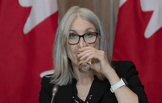 Indigenous Services Minister Patty Hajdu drinks water from a glass as she listens to speakers appearing virtually during a news conference, Thursday, April 28, 2022 in Ottawa. The federal government has set aside about $1.5 billion to compensate Indigenous people who have been without clean drinking water, the result of a class-action lawsuit initiated by First Nations communities. THE CANADIAN PRESS/Adrian Wyld