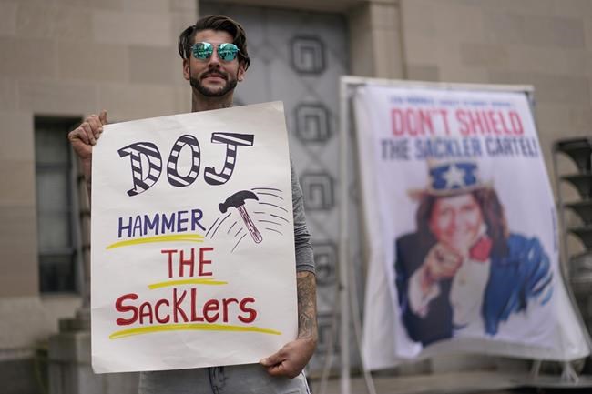 FILE - Nicholas Rivers of Maine, holds a sign that reads DOJ Hammer the Sacklers