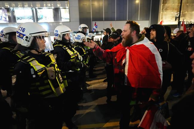 Protesters confront police during a demonstration, part of a convoy-style protest participants are calling