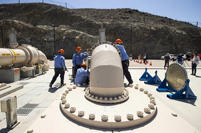 Southern Nevada Water Authority maintenance mechanics install a spacer flange after removing an energy dissipator at the Low Lake Level Pumping Station (L3P3) at Lake Mead National Recreation Area on Wednesday, April 27, 2022, outside of Las Vegas. The water supply for Las Vegas has marked a milestone, with the start of pumping through a new facility drawing water for some 2.4 million residents and 40 million tourists from deeper in Lake Mead and the dropping of the drought-depleted surface level falls below the first of three intakes at the crucial Colorado River reservoir behind Hoover Dam. (Chase Stevens/Las Vegas Review-Journal via AP)