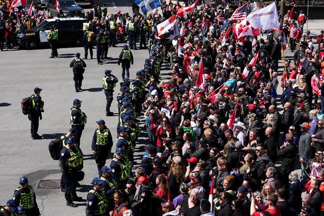Police hold the line as protesters gather during a demonstration, part of a convoy-style protest participants are calling