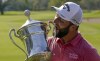 Jon Rahm, of Spain, celebrates with the championship trophy after winning the Mexico Open at Vidanta, in Puerto Vallarta, Mexico, Sunday, May 1, 2022. (AP Photo/Eduardo Verdugo)