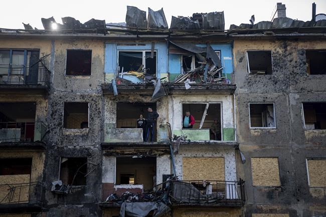 Local residents clean their apartments damaged by Russian shelling in Dobropillya, Donetsk region, eastern Ukraine, Saturday, April 30, 2022. Ukraine's Ambassador designate to Canada says Russia must be held accountable for sex crimes by its troops, including against children. (AP Photo/Evgeniy Maloletka)