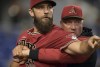 Arizona Diamondbacks' pitcher Madison Bumgarner, left, is restrained by bench coach Jeff Banister while arguing with umpires after the first inning of a baseball game against the against the Miami Marlins, Wednesday, May 4, 2022, in Miami. (AP Photo/Jim Rassol)