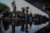 FILE - Demonstrators are reflected in a pond as they protest outside of the U.S. Courthouse in response to a leaked draft of the Supreme Court's opinion to overturn Roe v. Wade, in Los Angeles, March 3, 2022. (AP Photo/Ringo H.W. Chiu, File)