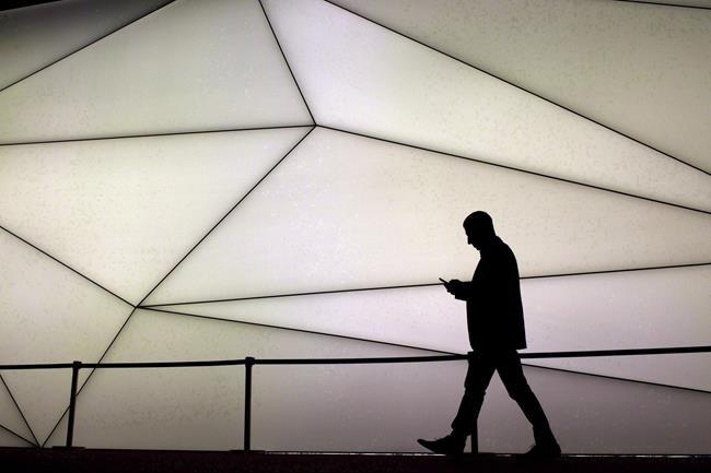 A man looks at his phone as he walks along the Samsung stand during the Mobile World Congress wireless show in Barcelona, Spain, on February 27, 2017. Canadians’ movements, including trips to the liquor store and pharmacy, were tracked via their mobile phones without their knowledge and sent to Ottawa to help it understand travel patterns during the COVID-19 pandemic, a report sent to a committee of MPs shows. THE CANADIAN PRESS/AP, Emilio Morenatti