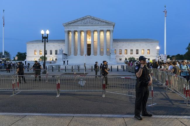 FILE - Demonstrators protest outside of the U.S. Supreme Court as law enforcement officers stand ready, May 3, 2022, in Washington. A leaked draft of a Supreme Court opinion overruling the landmark Roe v. Wade decision has thrust companies into the limelight on what’s arguably the most divisive issue in American politics. (AP Photo/Alex Brandon, File)