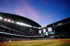 As the suns sets, Arizona Diamondbacks' Jose Herrera hits a foul ball off Colorado Rockies starting pitcher Chad Kuhl during the second inning of a baseball game Friday, May 6, 2022, in Phoenix. (AP Photo/Ross D. Franklin)