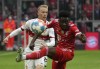Stuttgart's Chris Fuehrich, left, duels for the ball with Bayern's Alphonso Davies during the German Bundesliga soccer match between Bayern Munich and Stuttgart, at the Allianz Arena, in Munich, Germany, Sunday, May 8, 2022. (AP Photo/Michael Probst )