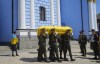Soldiers carry a coffin with remains of a volunteer soldier Oleksandr Makhov, a well-known Ukrainian journalist, killed by the Russian troops, at St Michael cathedral in Kyiv, Ukraine, Monday, May 9, 2022. The coffin is followed by Makhov's widow.(AP Photo/Efrem Lukatsky)