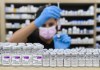 A pharmacist draws a dose behind vials of both Pfizer-BioNTech and Oxford-AstraZeneca COVID-19 vaccines in Toronto, Friday, June 18, 2021. THE CANADIAN PRESS/Nathan Denette