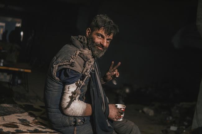 In this photo provided by Azov Special Forces Regiment of the Ukrainian National Guard Press Office, an Azov Special Forces Regiment's serviceman, injured during fighting against Russian forces, poses for a photographer inside the Azovstal steel plant in Mariupol, Ukraine, Tuesday, May 10, 2022. (Dmytro 'Orest' Kozatskyi/Azov Special Forces Regiment of the Ukrainian National Guard Press Office via AP)