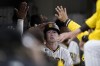 San Diego Padres' Jake Cronenworth is greeted in the dugout after scoring off an RBI-double by Manny Machado during the sixth inning of a baseball game against the Chicago Cubs, Tuesday, May 10, 2022, in San Diego. (AP Photo/Gregory Bull)