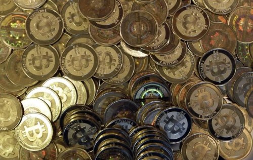 FILE - This April 3, 2013, file photo shows bitcoin tokens in Sandy, Utah. The Cuban government said Thursday, August 26, 2021, that it will start recognizing cryptocurrencies like Bitcoin as payment. With investors eager to get in early on new cryptocurrency projects, some unscrupulous developers have attracted investments, then walked away before building what they promised — leaving their supporters with worthless holdings. The rug pull, which gets its name from the expression “pulling the rug out,” is part of a long history of investment schemes. But cryptocurrencies have particular risks due to loose regulations for fundraising.  (AP Photo/Rick Bowmer, File)