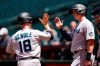 Miami Marlins' Joey Wendle (18) celebrates his two-run home run against the Arizona Diamondbacks with Marlins' Garrett Cooper, right, during the first inning of a baseball game Wednesday, May 11, 2022, in Phoenix. (AP Photo/Ross D. Franklin)