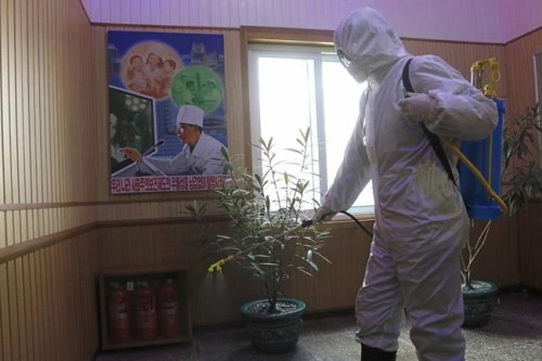 FILE- An official of the Hygienic and Anti-epidemic Center in Phyongchon District disinfect the corridor of a building in Pyongyang, North Korea, on Feb. 5, 2021. The Korean Central News Agency said Thursday, May 12, 2022, tests from an unspecified number of people in the capital Pyongyang confirmed that they were infected with the omicron variant. (AP Photo/Jon Chol Jin, File)