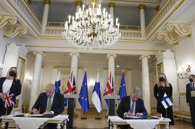 British Prime Minister Boris Johnson, left, and Finland's President Sauli Niinisto sign a security assurance, at the Presidential Palace in Helsinki, Finland, Wednesday, May 11, 2022. Britain has signed a security assurance with Sweden and its neighbor Finland, that are both pondering whether to join NATO following Russia's invasion of Ukraine, pledging to