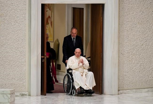 Pope Francis arrives in a wheelchair for an audience with members of the Italian Civil Aviation Authority (ENAC) in the Paul VI Hall at The Vatican, Friday, May 13, 2022. Pope Francis suffers from strained ligaments in his right knee. (AP Photo/Andrew Medichini)