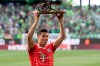 Bayern's Robert Lewandowski lifts the trophy after he was awarded as top scorer of the German Bundesliga after the soccer match between VfL Wolfsburg and Bayern Munich in Wolfsburg, Germany, Saturday, May 14, 2022. (Swen Pfoertner/dpa via AP)