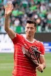 Bayern's Robert Lewandowski waves with the trophy after he was awarded as top scorer of the German Bundesliga after the soccer match between VfL Wolfsburg and Bayern Munich in Wolfsburg, Germany, Saturday, May 14, 2022. (Swen Pfoertner/dpa via AP)