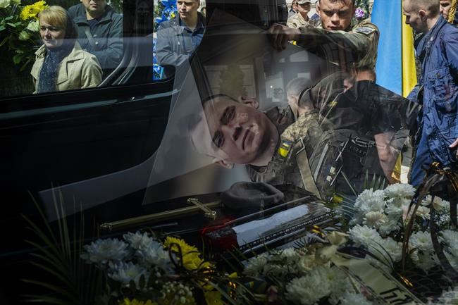 Relatives and friends attend the funeral of Melnyk Andriy, 23, a Ukrainian military servicemen who was killed in Kharkiv province, in Lviv, Ukraine, Saturday, May 14, 2022. (AP Photo/Emilio Morenatti)