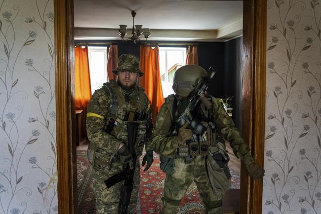 Ukrainian servicemen inspect a house during a reconnaissance mission in a recently retaken village on the outskirts of Kharkiv, east Ukraine, Saturday, May 14, 2022. (AP Photo/Mstyslav Chernov)