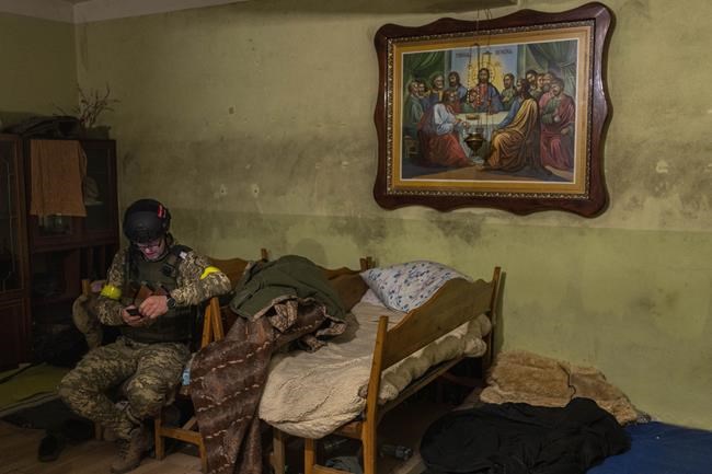 A Ukrainian National Guard soldier takes a break in a house used as temporary base in a recently retaken village on the outskirts of Kharkiv, east Ukraine, Saturday, May 14, 2022. (AP Photo/Bernat Armangue)