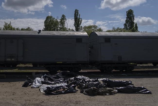 Bodies of dead Russian soldiers lay on the floor during an identification process in Kharkiv, east Ukraine, Saturday, May 14, 2022. The bodies of more than 41 Russian soldiers who were found after battles around Kharkiv are being stored in the refrigerated coach. (AP Photo/Vasilisa Stepanenko)