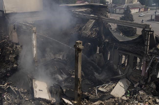 A Ukrainian firefighter works inside a destroyed cultural center in Derhachi, eastern Ukraine, Sunday, May 15, 2022. A Russian airstrike destroyed the venue on May 12. (AP Photo/Bernat Armangue)