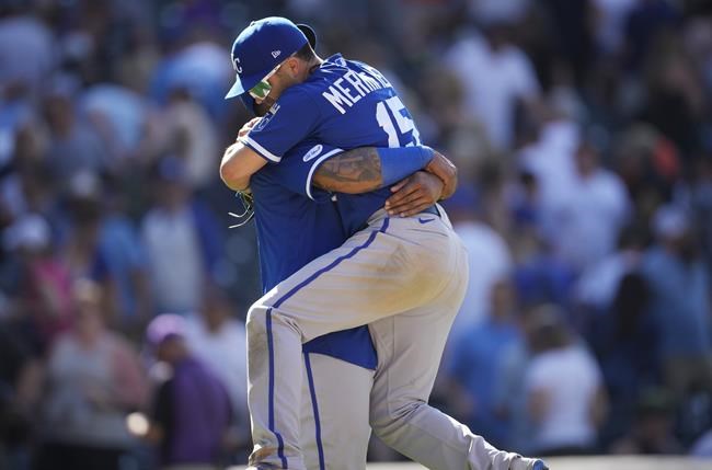 Kansas City Royals second baseman Whit Merrifield, front, jumps into the arms of Salvador Perez to celebrate after the ninth inning of a baseball game against the Colorado Rockies, Sunday, May 15, 2022, in Denver. (AP Photo/David Zalubowski)