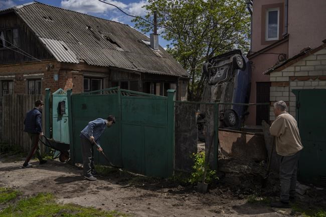 Residents clear the rubble from their house damaged during a shelling in Kharkiv, Ukraine, Monday, May 16, 2022. (AP Photo/Bernat Armangue)
