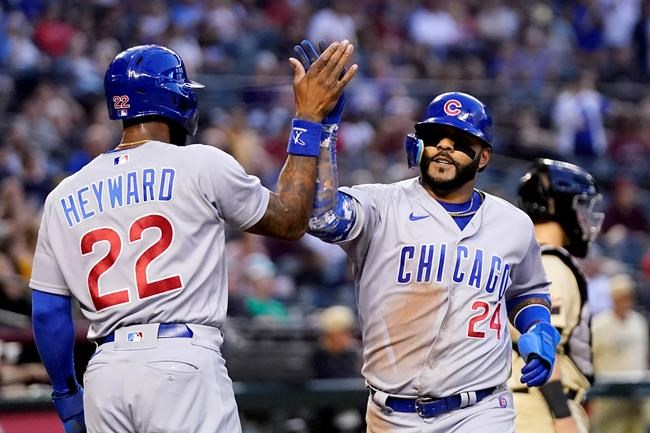 Chicago Cubs' Jonathan Villar (24) and Jason Heyward (22) celebrate their runs scored against the Arizona Diamondbacks during the third inning of a baseball game Friday, May 13, 2022, in Phoenix. (AP Photo/Ross D. Franklin)