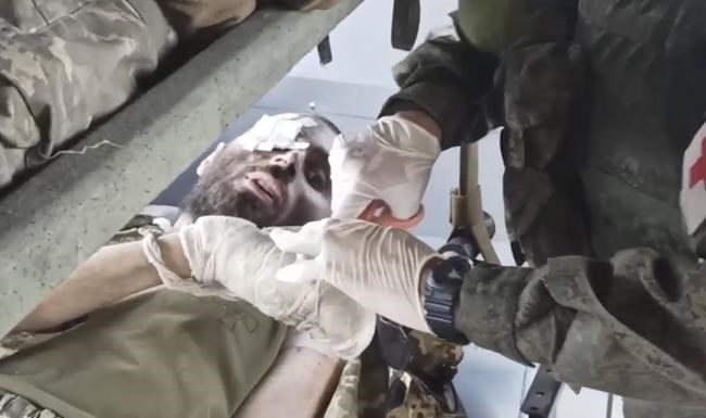 In this photo taken from video released by the Russian Defense Ministry Press Service on Tuesday, May 17, 2022, wounded Ukrainian servicemen receive treatment in a bus as they are being evacuated from the besieged Azovstal steel plant in Mariupol, Ukraine. More than 260 fighters, some severely wounded, were pulled from a steel plant on Monday that is the last redoubt of Ukrainian fighters in the city and transported to two towns controlled by separatists, officials on both sides said. (Russian Defense Ministry Press Service via AP)