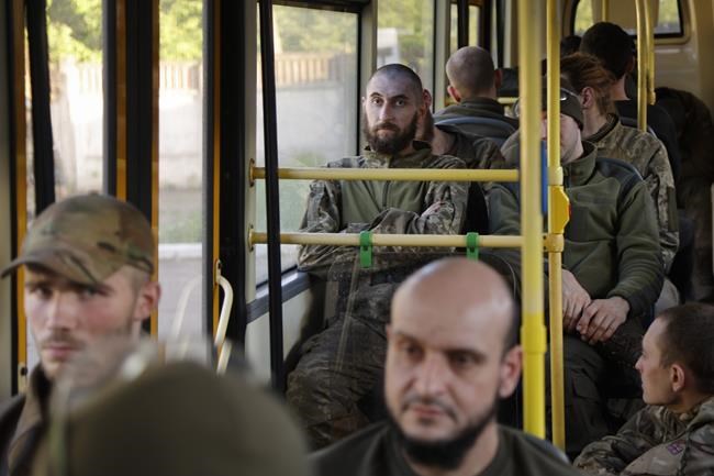Ukrainian servicemen sit in a bus after they were evacuated from the besieged Mariupol's Azovstal steel plant, near a remand prison in Olyonivka, in territory under the government of the Donetsk People's Republic, eastern Ukraine, Tuesday, May 17, 2022. More than 260 fighters, some severely wounded, were pulled from a steel plant on Monday that is the last redoubt of Ukrainian fighters in the city and transported to two towns controlled by separatists, officials on both sides said. (AP Photo/Alexei Alexandrov)