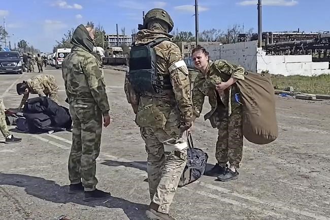 In this photo taken from video released by the Russian Defense Ministry Press Service on Wednesday, May 18, 2022, Russian servicemen frisk Ukrainian servicemen after they leaved the besieged Azovstal steel plant in Mariupol, Ukraine.(Russian Defense Ministry Press Service via AP)