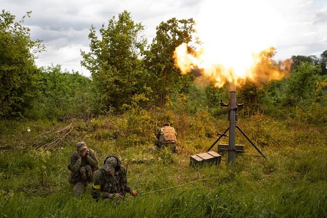 Ukrainian servicemen fire mortars towards Russian positions in east Kharkiv region, Ukraine, Tuesday, May 17, 2022. (AP Photo/Bernat Armangue)
