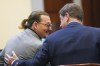 Actor Johnny Depp speaks with his legal team in the courtroom at the Fairfax County Circuit Courthouse in Fairfax, Va., Thursday, May 19, 2022. Actor Johnny Depp sued his ex-wife Amber Heard for libel in Fairfax County Circuit Court after she wrote an op-ed piece in The Washington Post in 2018 referring to herself as a 