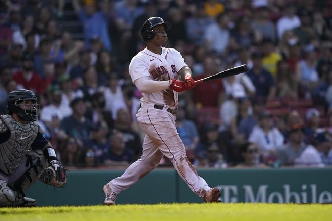 Boston Red Sox's Rafael Devers, right, watches his home run in the third inning in a baseball game against the Seattle Mariners, Saturday, May 21, 2022, in Boston. (AP Photo/Robert F. Bukaty)