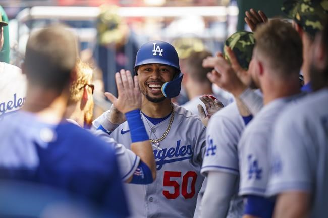 Los Angeles Dodgers' Mookie Betts, center, celebrates with teammates after his solo home run during the third inning of a baseball game against the Philadelphia Phillies, Sunday, May 22, 2022, in Philadelphia. (AP Photo/Chris Szagola)