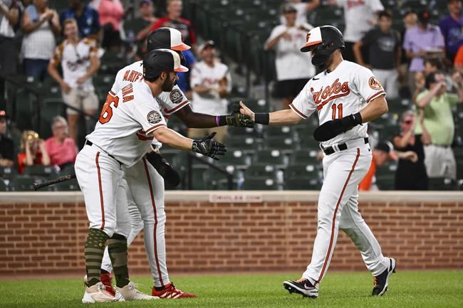 Baltimore Orioles' Chris Owings (11) is greeted by Ryan McKenna, left, and Jorge Mateo after scoring a run on a hit by Austin Hays against Tampa Bay Rays starting pitcher Ryan Thompson during the ninth inning of a baseball game, Sunday, May 22, 2022, in Baltimore. (AP Photo/Terrance Williams)