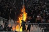 FILE - PAOK fans cheer as a fire burns seats before the Greek Cup Final soccer match between Panathinaikos and PAOK at the Olympic stadium in Athens, Greece, Saturday, May 21, 2022. In a season when soccer violence has made an ugly comeback, a potential menace hangs over the Europa Conference League final between Dutch club Feyenoord and Italy's Roma in the Albanian capital, Tirana, on Wednesday, May 25, 2022. (AP Photo/Thanassis Stavrakis, File)