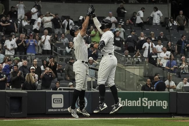 New York Yankees' Aaron Judge, right, high-fives teammate Giancarlo Stanton, left, after hitting a home run in the first inning of a baseball game against the Baltimore Orioles, Monday, May 23, 2022, in New York. (AP Photo/Bebeto Matthews)