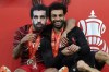 Liverpool's Thiago, wearing a mask of Mohamed Salah, embraces Salah after they won the English FA Cup final soccer match between Chelsea and Liverpool, at Wembley stadium, in London, Saturday, May 14, 2022. Liverpool won 6-5 on penalties after the game ended in a goalless draw. (AP Photo/Ian Walton)